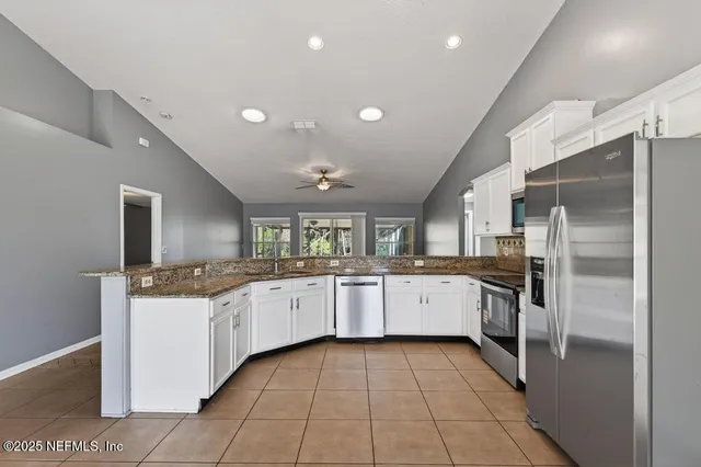 a bathroom with a sink a counter top space stainless steel appliances and cabinets