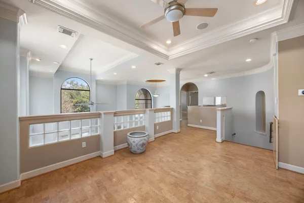 an empty room with windows and ceiling fan