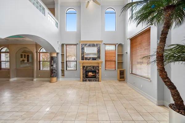 a view of a livingroom with a fireplace a chandelier and stairs