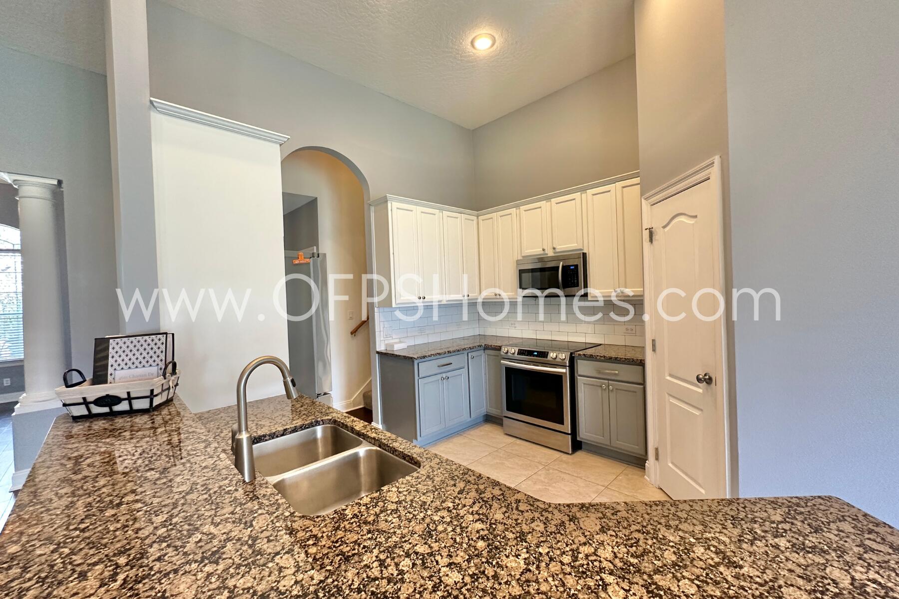 4611 Chanan Drive Crestview, FL 32539 - Photo 14 of 36 a kitchen with stainless steel appliances granite countertop a stove top oven a sink dishwasher a dining table and chairs with wooden floor