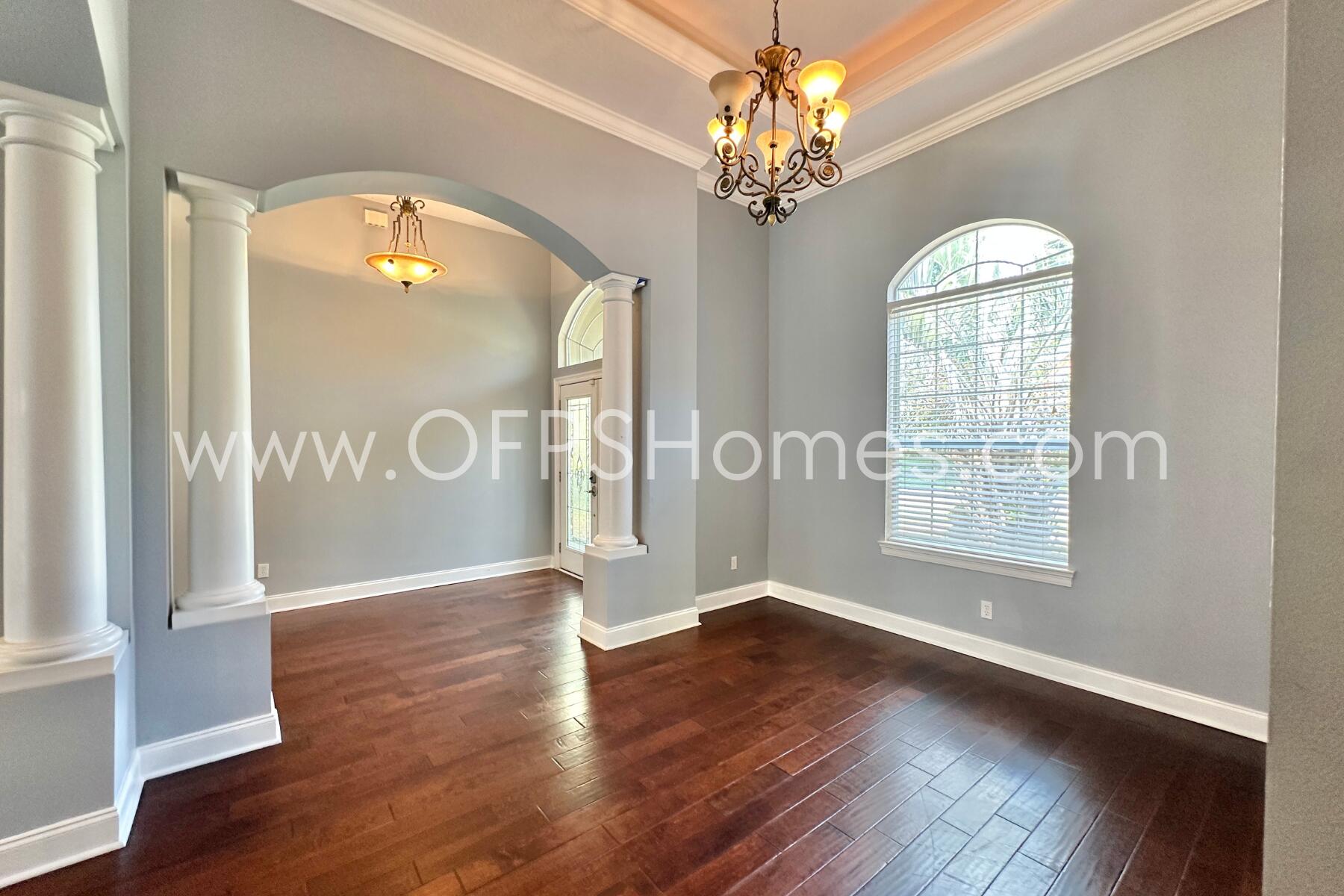 4611 Chanan Drive Crestview, FL 32539 - Photo 9 of 36 an empty room with wooden floor chandelier and glass door