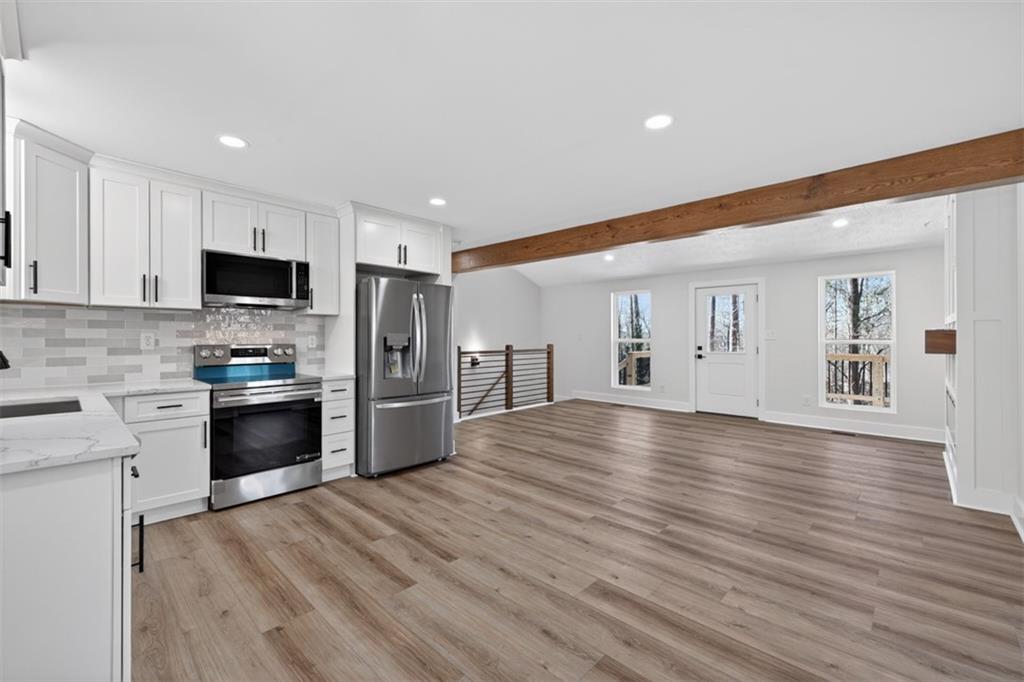 4190 Heather Way Cumming, GA 30041 - Photo 12 of 45 a large kitchen with stainless steel appliances granite countertop a stove and a refrigerator