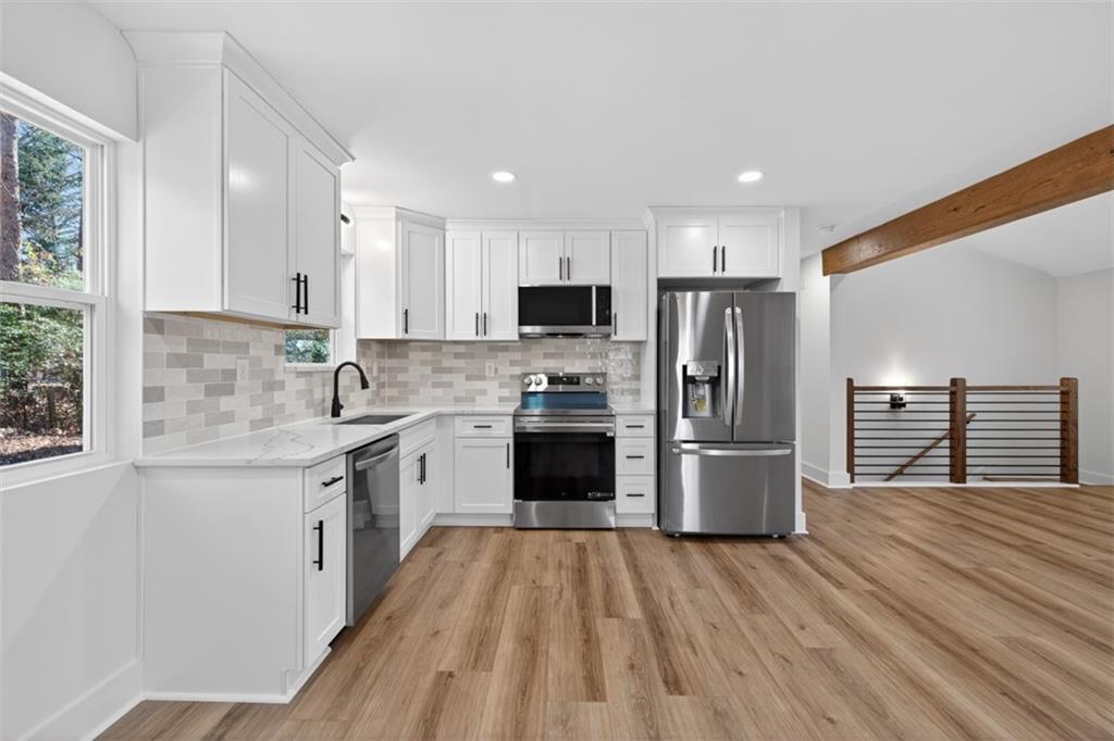 4190 Heather Way Cumming, GA 30041 - Photo 16 of 45 a kitchen with refrigerator a stove top oven a sink and dishwasher with wooden floor