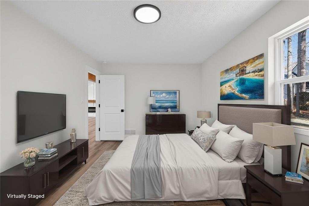 4190 Heather Way Cumming, GA 30041 - Photo 17 of 45 a bedroom with a bed and a flat screen tv