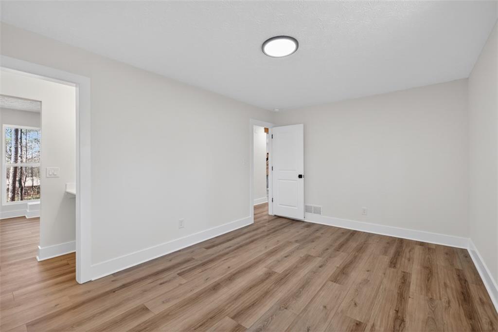 4190 Heather Way Cumming, GA 30041 - Photo 19 of 45 a view of an empty room with wooden floor and a window