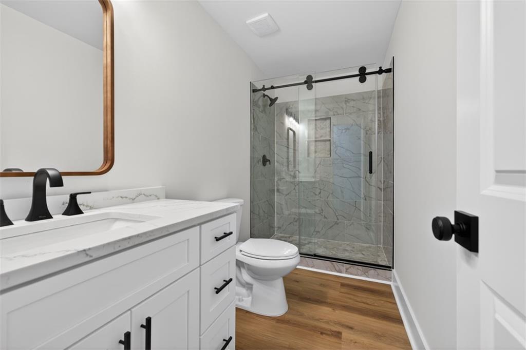 4190 Heather Way Cumming, GA 30041 - Photo 21 of 45 a bathroom with a granite countertop sink toilet and shower