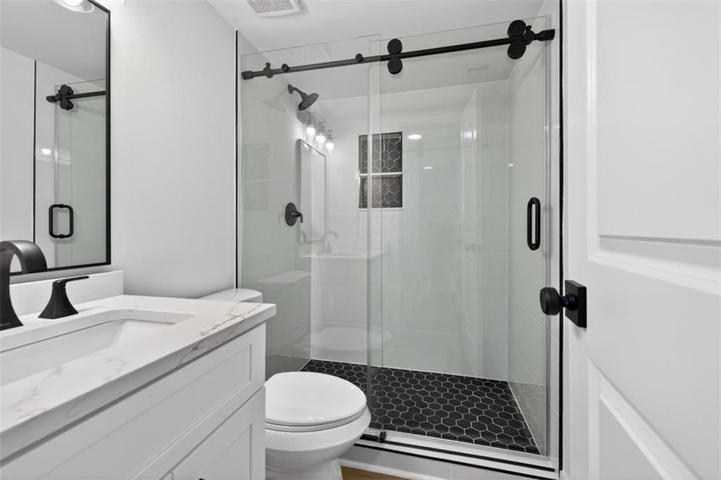 4190 Heather Way Cumming, GA 30041 - Photo 27 of 45 a bathroom with a granite countertop sink toilet and shower