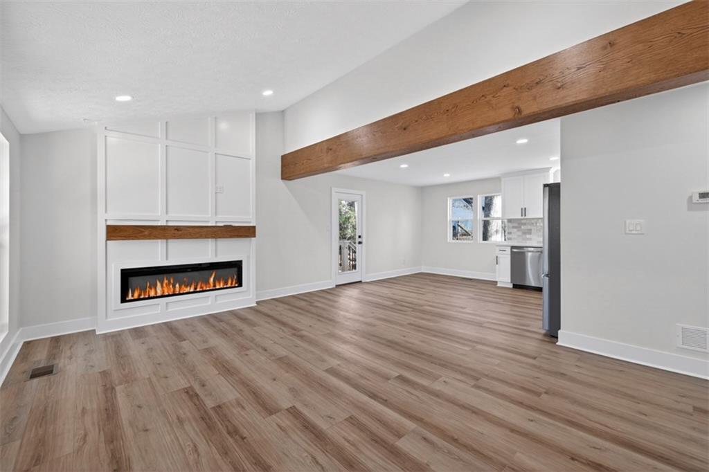 4190 Heather Way Cumming, GA 30041 - Photo 9 of 45 a view of an empty room with a fireplace and wooden floor