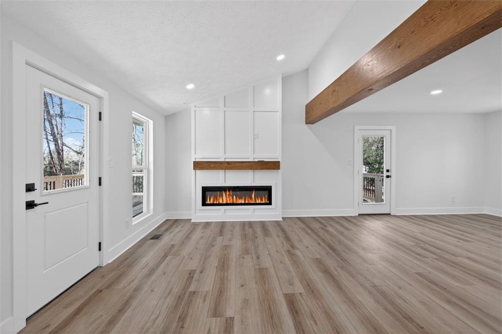 4190 Heather Way Cumming, GA 30041 - Photo 10 of 45 a view of empty room with wooden floor and fireplace
