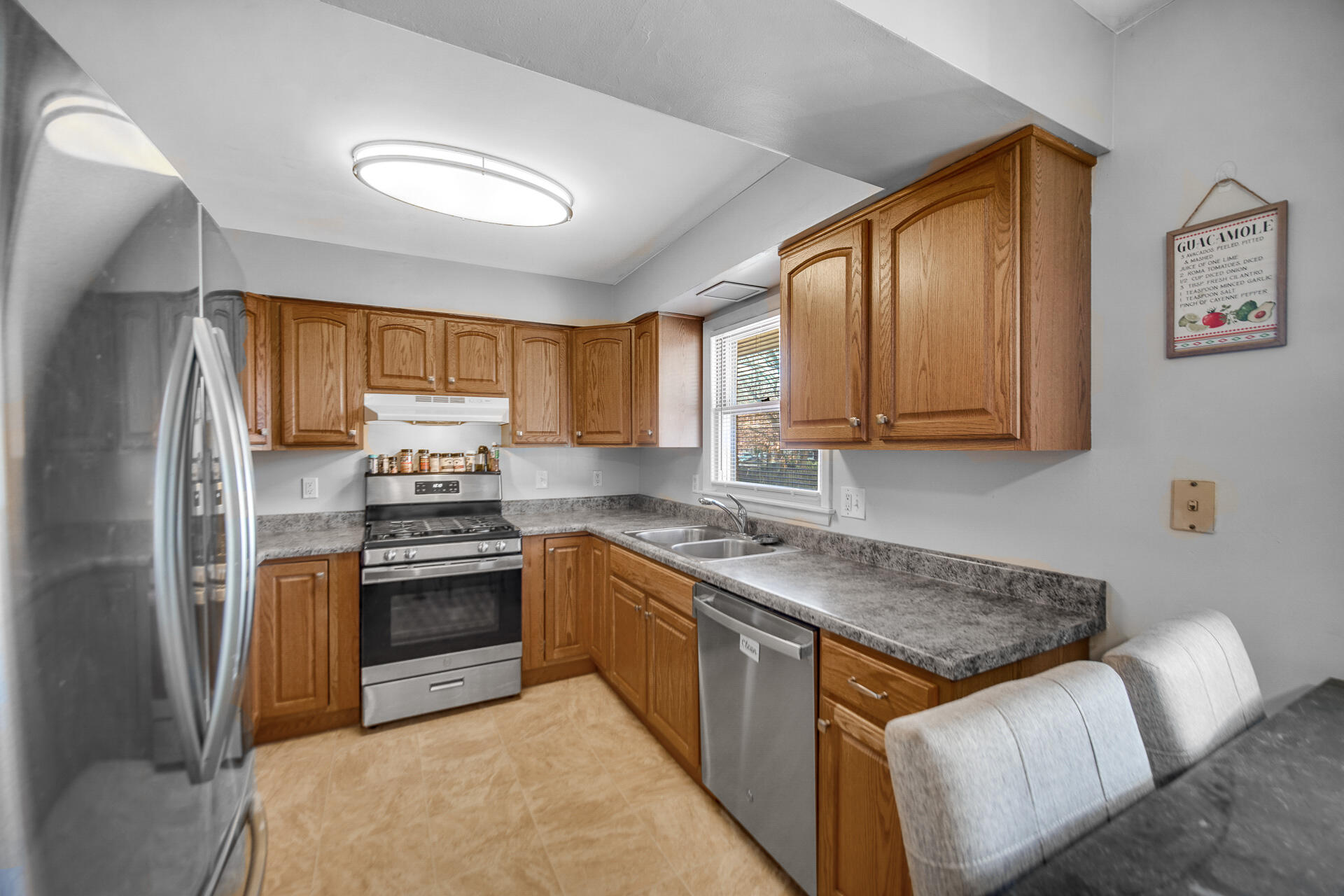 612 Almond Street Northwest De Motte, IN 46310 - Photo 8 of 27 a kitchen with stainless steel appliances granite countertop a stove a sink dishwasher and a refrigerator