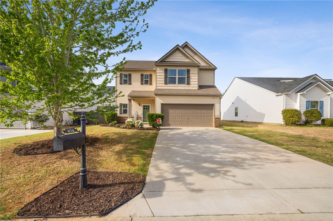 874 Wild Orchard Lane Woodruff, SC 29388 - Photo 18 of 35 This two-story home features a welcoming facade with a well-maintained lawn and an attached garage.