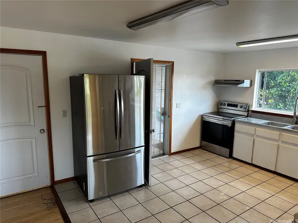 a kitchen with a refrigerator sink and cabinets