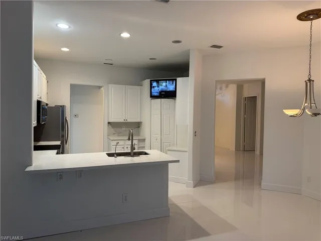 a kitchen with stainless steel appliances a refrigerator a sink a stove a microwave and cabinets