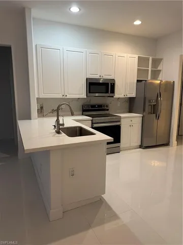 a kitchen with kitchen island sink refrigerator and cabinets