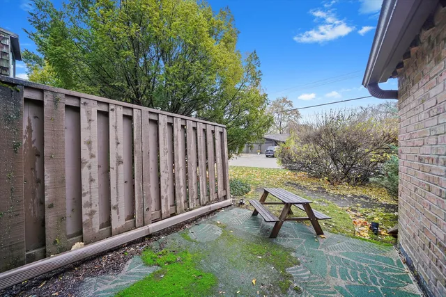 a view of a wooden bench in backyard of house