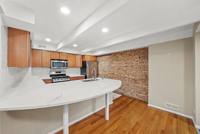 a kitchen with stainless steel appliances a refrigerator and a stove top oven