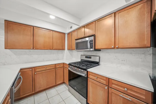 a kitchen with stainless steel appliances granite countertop a sink stove and microwave