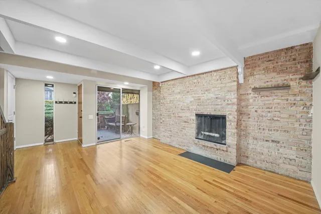 a view of empty room with wooden floor and fireplace
