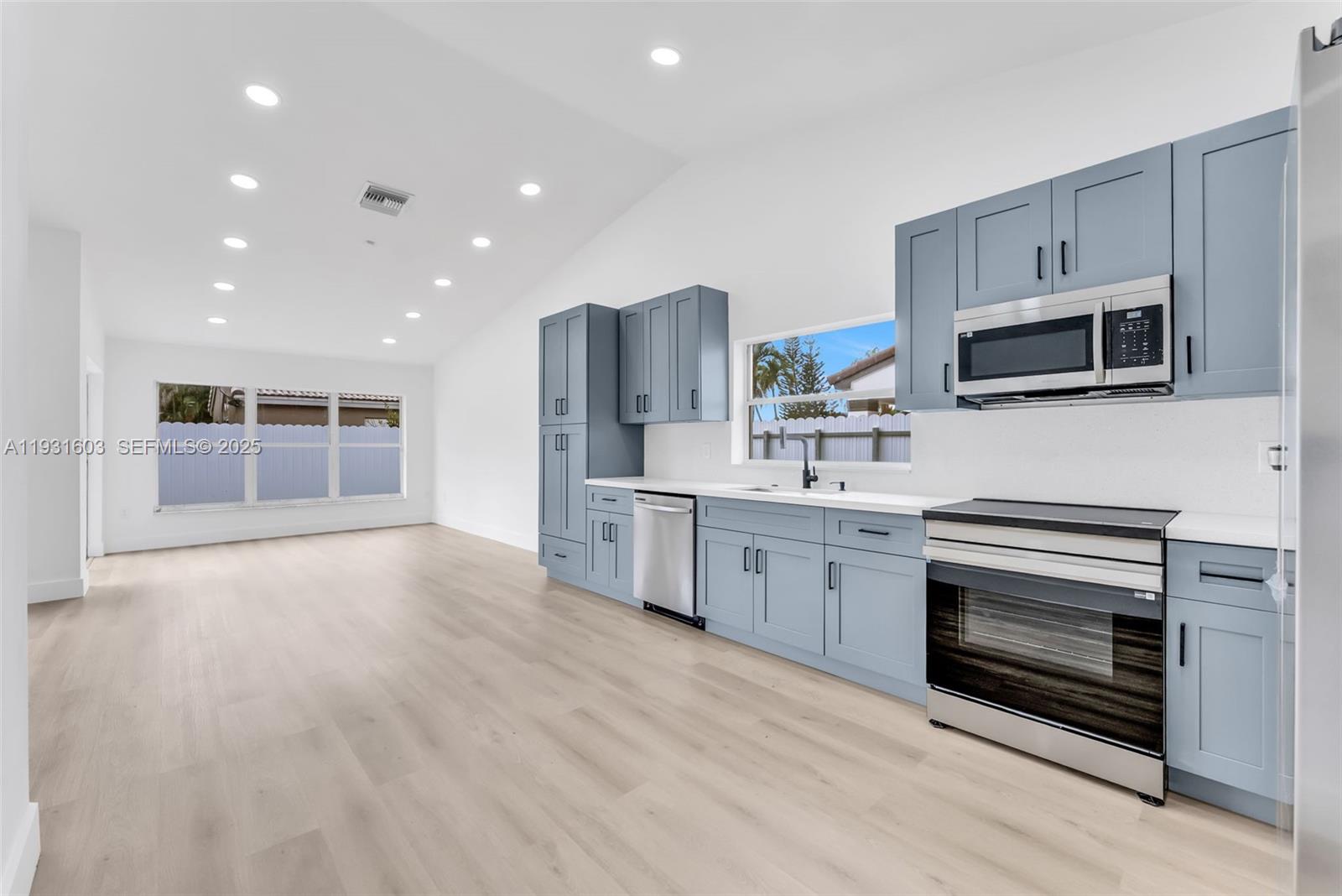 16054 Southwest 77th Terrace Miami, FL 33193 - Photo 13 of 42 a kitchen with stainless steel appliances granite countertop a stove a sink and a microwave