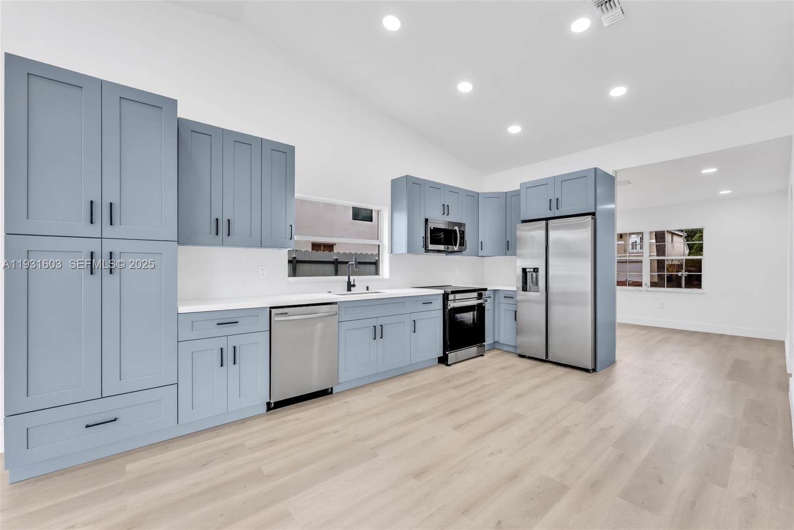 16054 Southwest 77th Terrace Miami, FL 33193 - Photo 14 of 42 a kitchen with white cabinets and white appliances