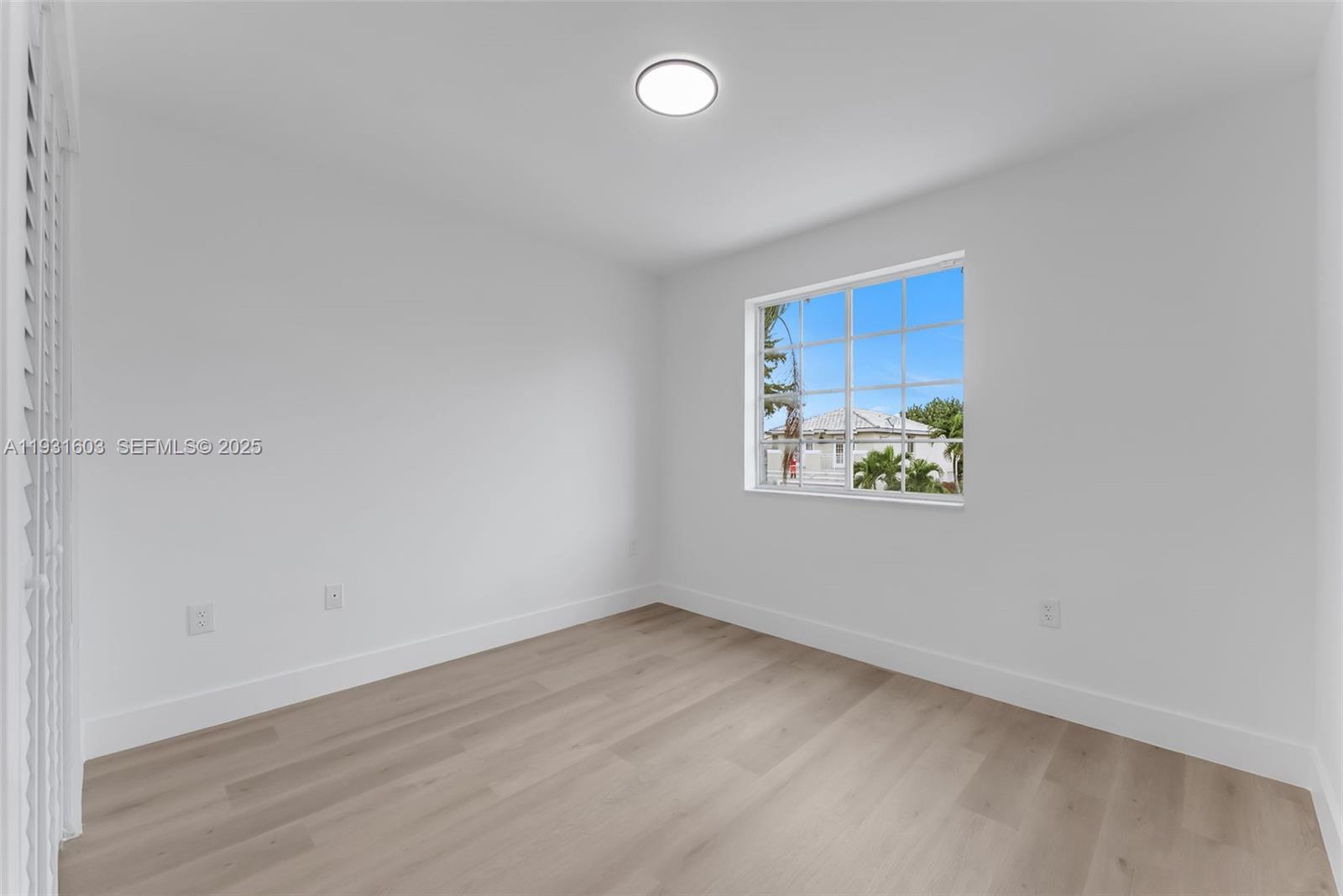16054 Southwest 77th Terrace Miami, FL 33193 - Photo 25 of 42 a view of an empty room with wooden floor and a window