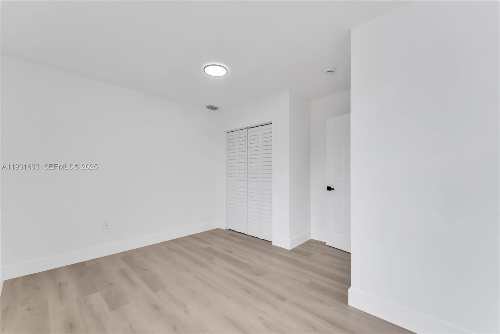 16054 Southwest 77th Terrace Miami, FL 33193 - Photo 33 of 42 a view of a room with wooden floor and white walls