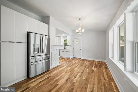 a kitchen with kitchen island wooden floor appliances and a window