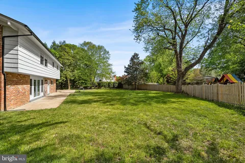 a view of house with backyard and trees