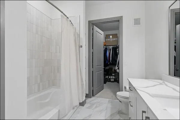 a bathroom with a granite countertop sink a toilet and shower