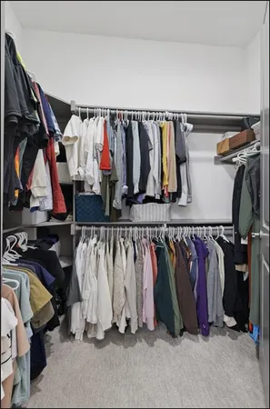 a view of walk in closet with clothes and shoes