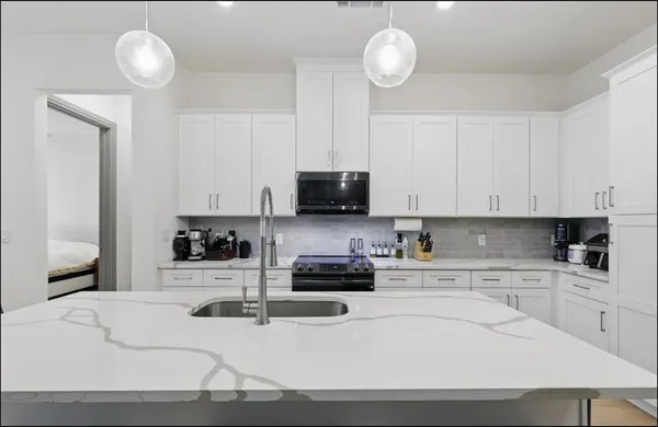a kitchen with stainless steel appliances a stove a sink and cabinets