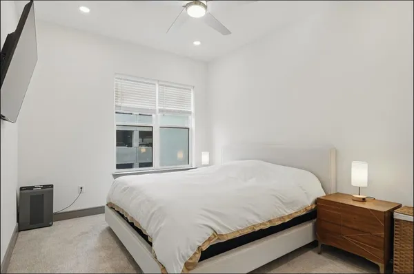 a bedroom with a bed and a ceiling fan