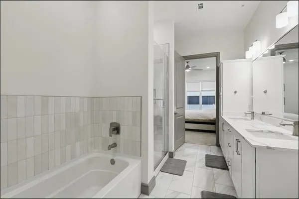 a bathroom with a tub a sink and a mirror