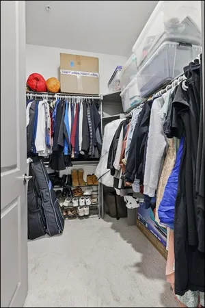 a view of walk in closet with clothes and shoes