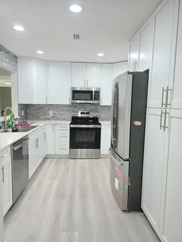 a kitchen with stainless steel appliances a refrigerator sink and microwave