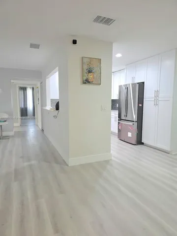 a view of a kitchen with refrigerator and front door