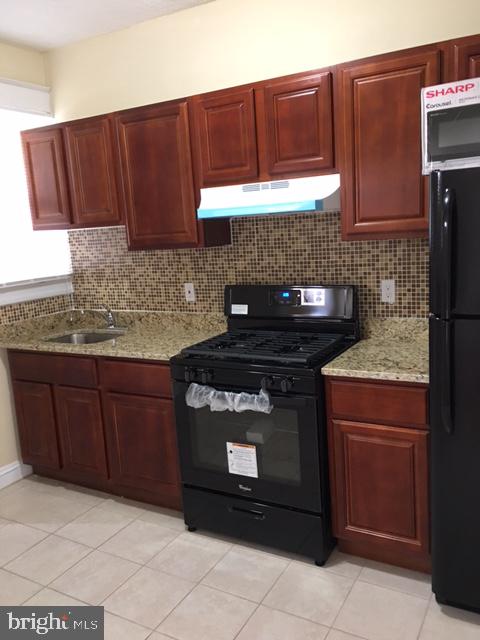 418 Edgewood Street Baltimore, MD 21229 - Photo 4 of 10 a kitchen with granite countertop cabinets and a stove top oven