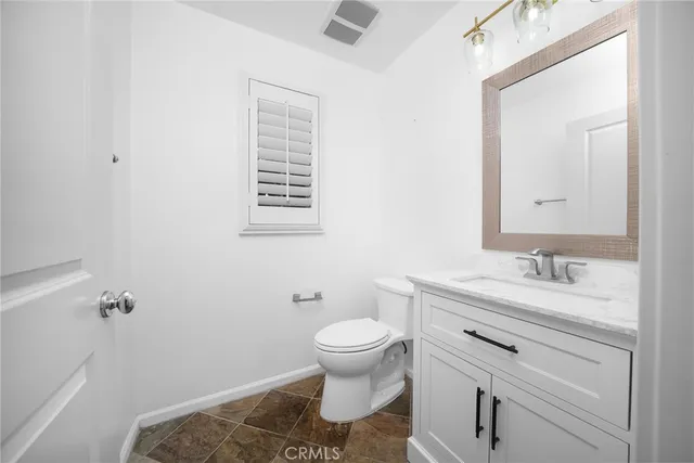 a bathroom with a granite countertop sink a toilet and a bathtub
