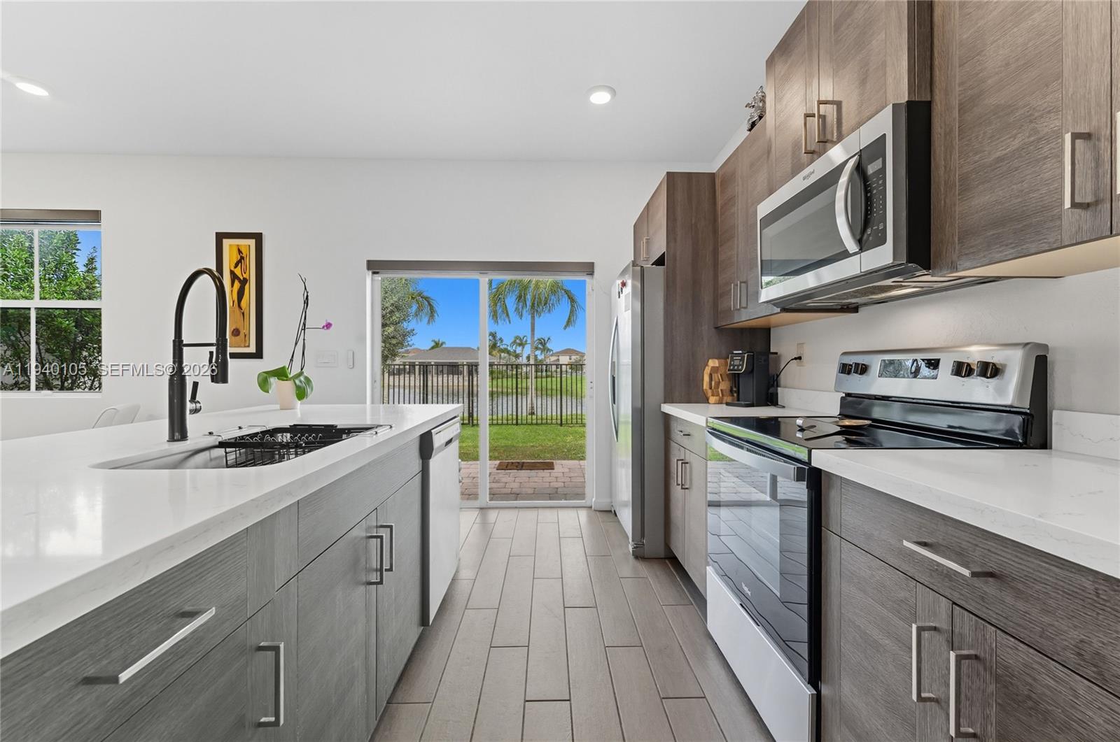 805 South E 18th Street, Unit 805 Homestead, FL 33034 - Photo 12 of 29 a kitchen with stainless steel appliances granite countertop a stove a sink and a microwave