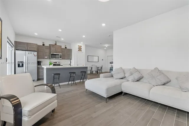 a living room with furniture and kitchen view