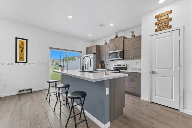 a kitchen with stainless steel appliances a refrigerator and a stove top oven