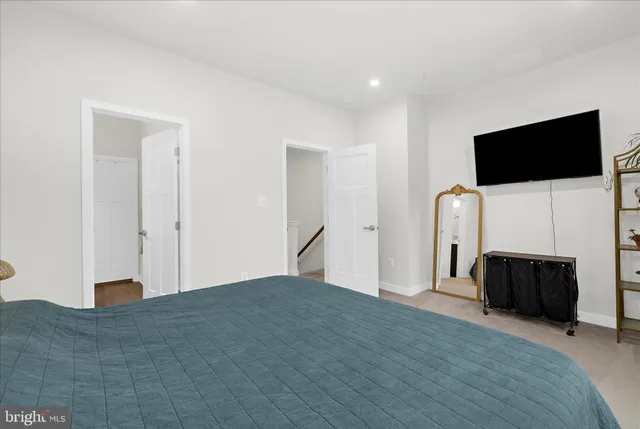 a view of a livingroom with entryway flat screen tv wooden shelves and closet