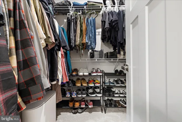 a view of walk in closet with clothes and shoes