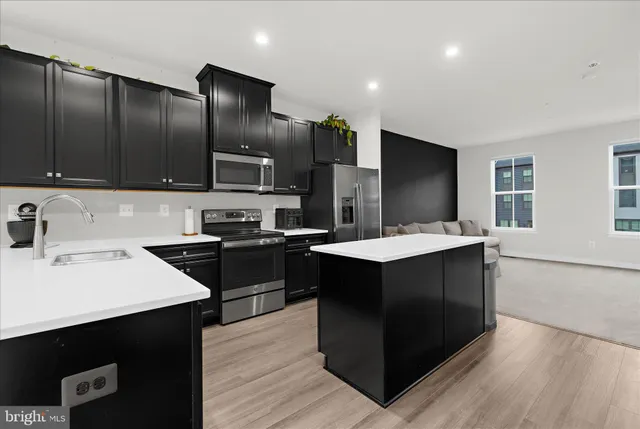 a kitchen with granite countertop a sink cabinets and stainless steel appliances