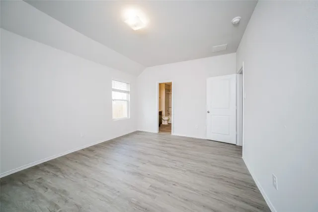 an empty room with wooden floor and window