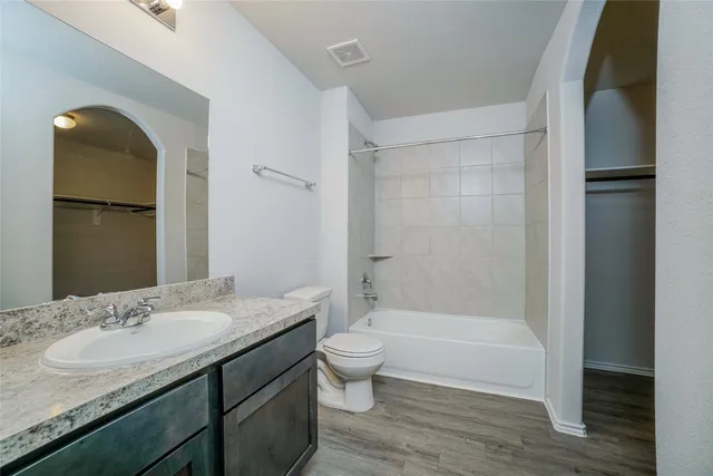 a bathroom with a granite countertop sink toilet and shower