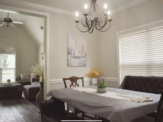 a view of a dining room with furniture a chandelier and wooden floor