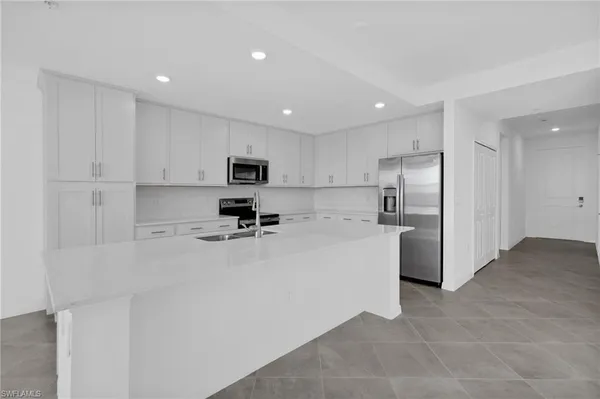 a kitchen with cabinets a sink and white stainless steel appliances