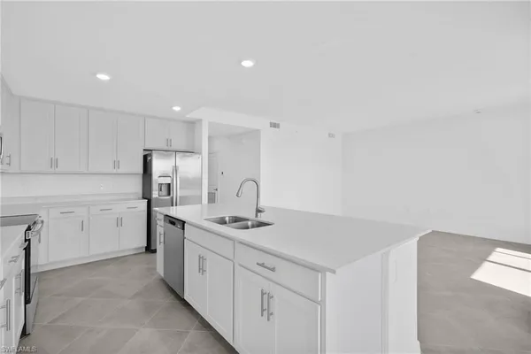 a kitchen with white cabinets stainless steel appliances and sink