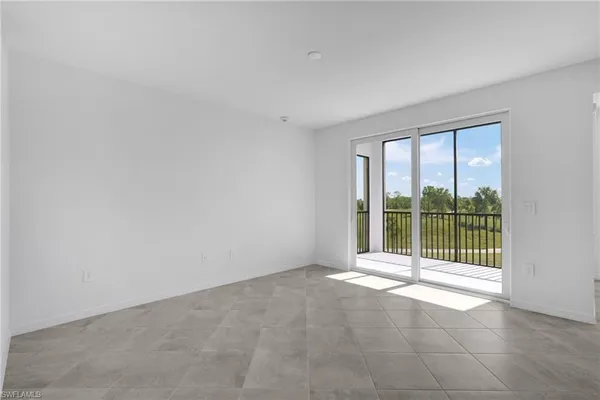 an empty room with floor to ceiling window and an outdoor view